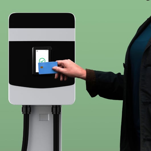 A person holds a card at a charging station for electric vehicles.